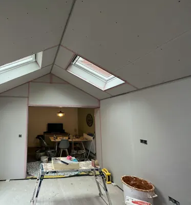 Before: Plasterboard walls and a vaulted ceiling around two roof windows